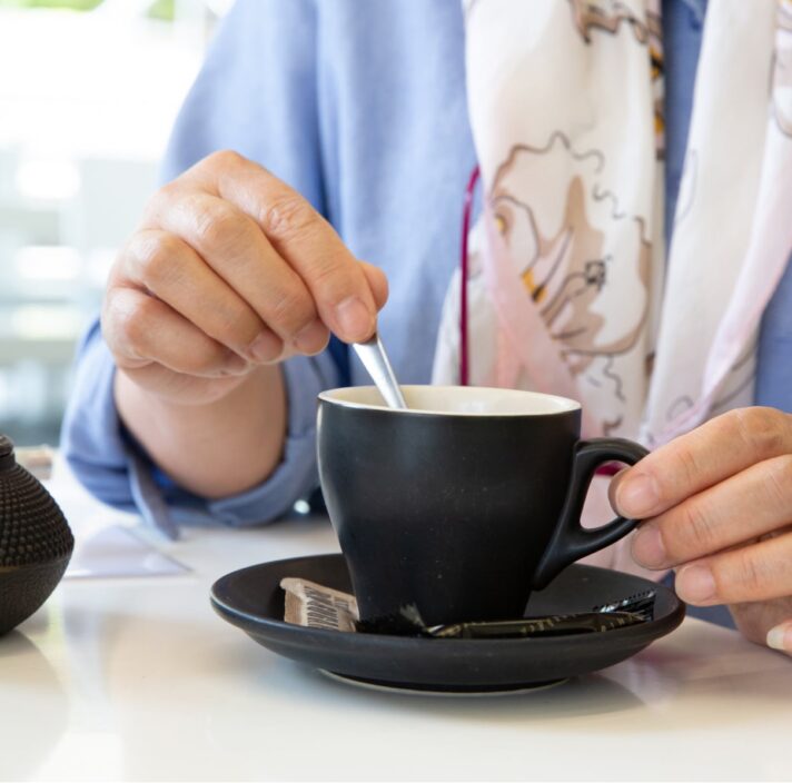 A person stirring a cup of tea.