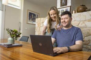 Two people looking at a laptop on a table