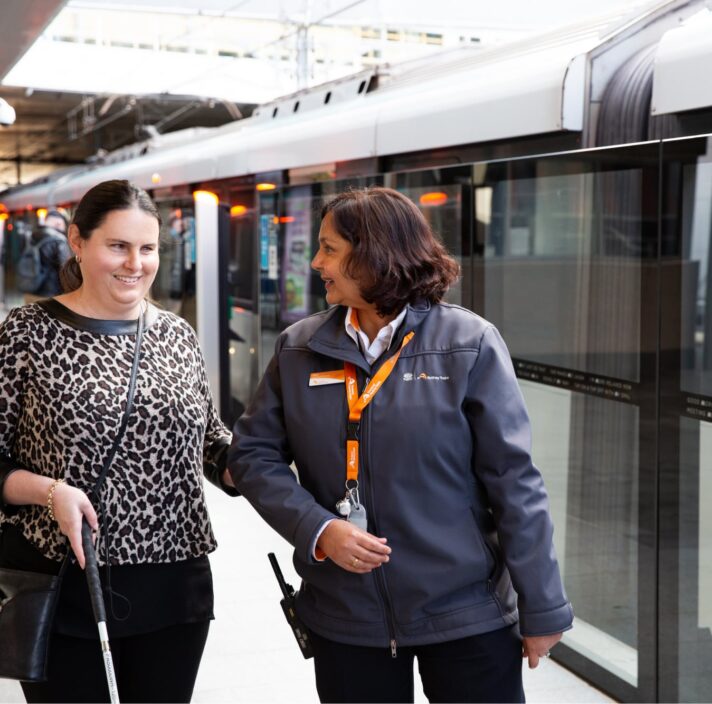 Nicole being guided by a station attendant on a train platform