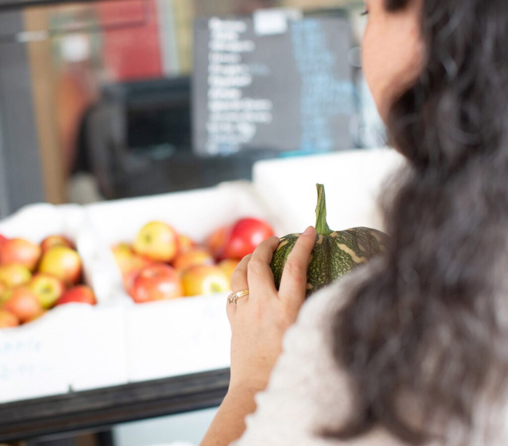 A person holding fresh produce at the market.
