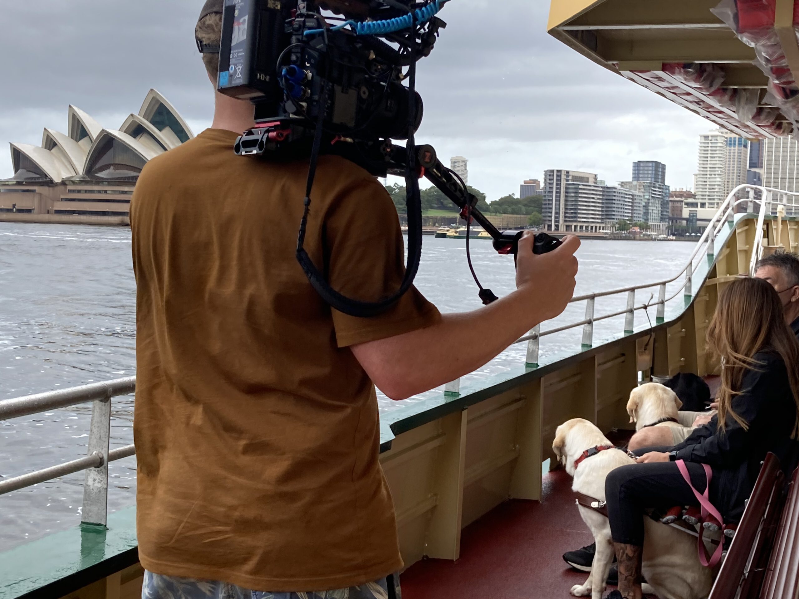 Camera crew filming in front of the Sydney Opera House