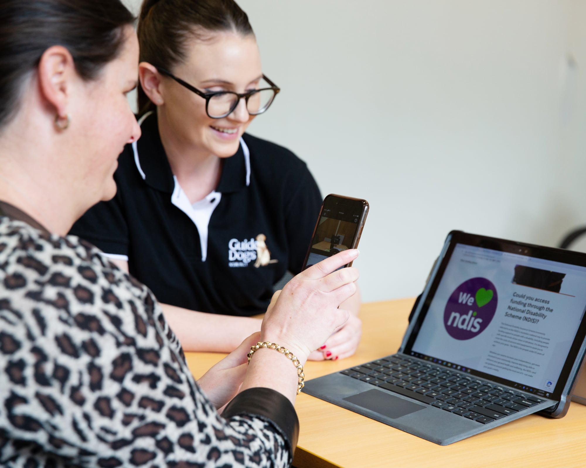 Guide Dogs Client learning to use assistive features on a smart phone and laptop.