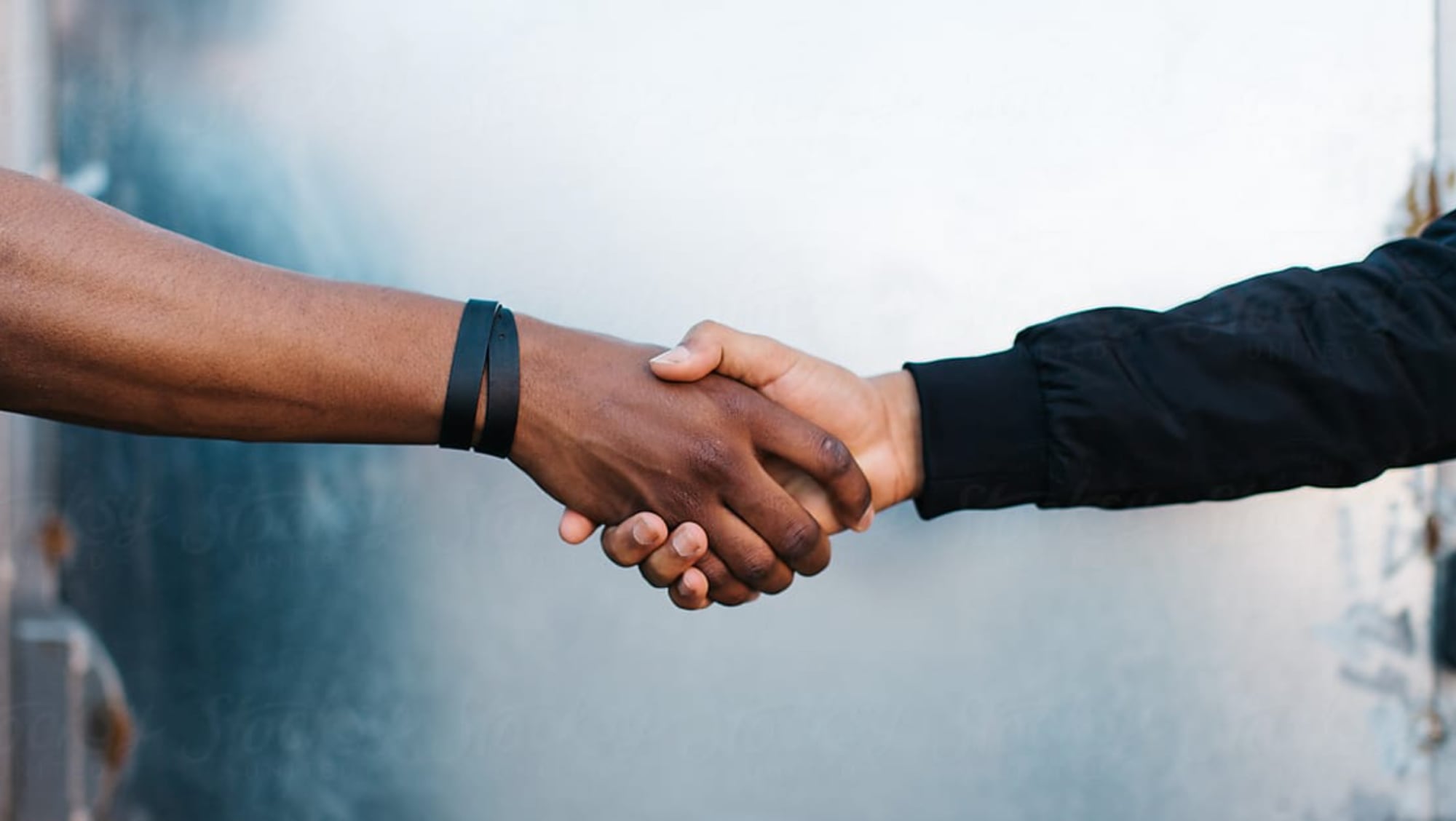 A close up image of two people shaking hands.