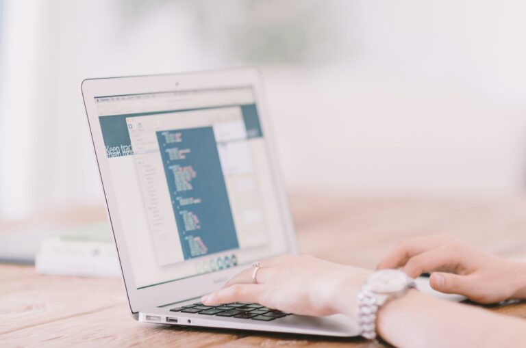 laptop with two hands typing on it