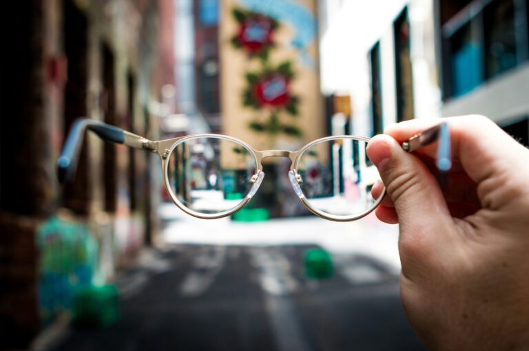 a hand holding up a pair of glasses